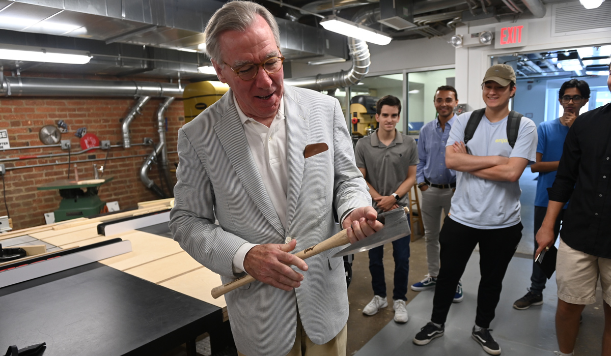 John Garvey holding an ax during visit to an architecture class 